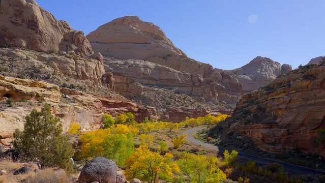 Establishing shot of mountain trail with red rocks background in Hickman Natural Bridge Trail, Capital Reef National Park, Utah, North America. Day time on October 2023. Still camera view. ProRes 422 