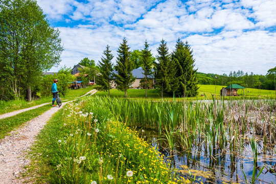 Cyclist on gravel road In Suwalski Landscape Park during spring season, Podlasie, Poland