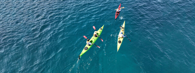 Aerial drone ultra wide photo of athletes competing with rowing in sport canoe in deep emerald...