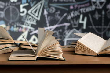 open books lie on a table on a blackboard background