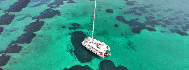 Aerial drone ultra wide photo of beautiful catamaran sailing yacht anchored in tropical exotic turquoise sea exotic bay