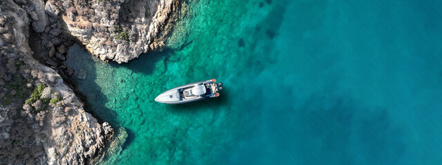 Aerial drone top down ultra wide photo with copy space of inflatable speed boat anchored in...