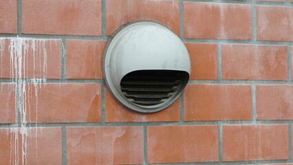 Round ventilation system on red brick wall