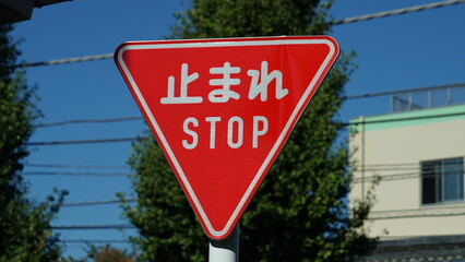 Red stop traffic sign on Japanese road, text means stop
