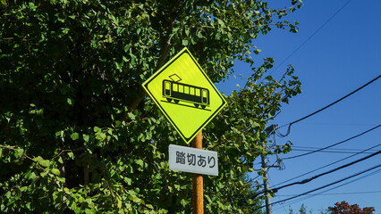 Train caution sign and railroad crossing traffic sign in Japan, the text means there is a railroad...
