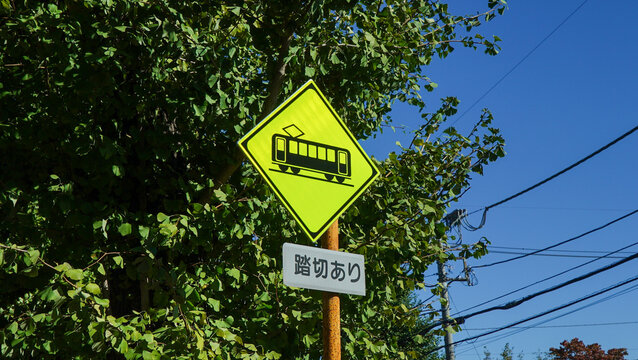 Train caution sign and railroad crossing traffic sign in Japan, the text means there is a railroad crossing