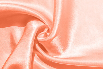 Color of the year 2024. Peach pastel background. Trendy abstract silk wallpaper. Modern silk fabric...