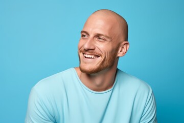 Portrait of a smiling young man in a blue t-shirt on a blue background