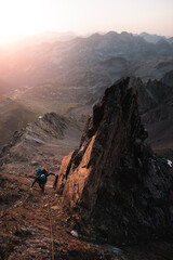 Fototapeta premium Mountaineer climbs among sharp rocks illuminated by the sunrise in an alpine adventure in the Pyrenees