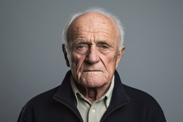 Portrait of an old man with wrinkles on his face. Gray background.