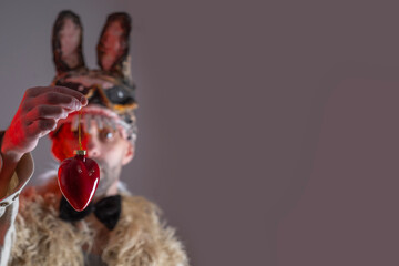 cringe hare man, young guy in cringe in scary rabbit mask looks at heart, concept murderous love,...