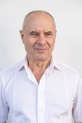 Obraz premium close-up of charismatic mature man, senior 60 years old looks carefully examines wrinkles on face, skin folds, age-related skin changes, aesthetic cosmetology, psychotherapy and emotional well-being