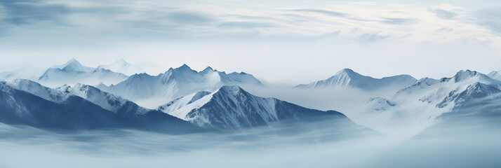 a panoramic view of snowy mountains with snow covered peaks covered with fog and snow in winters