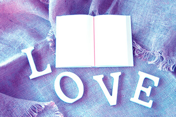 見開きの本とLOVEの文字（白い本と文字と紫と青の背景、ジュートの背景）