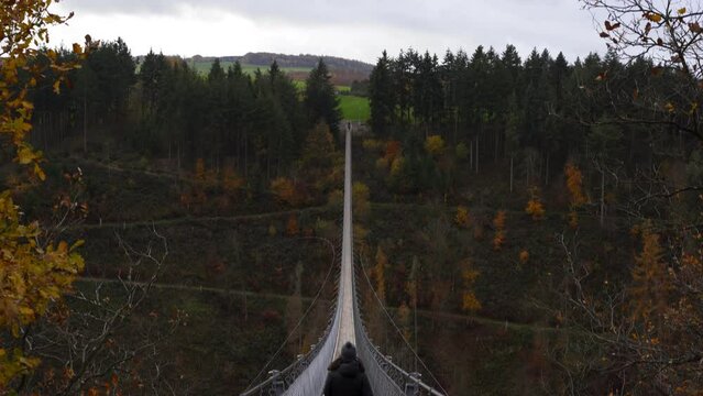 Woman walking in Geierlay suspension bridge in Germany