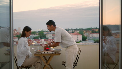 Caring husband serving table hotel balcony closeup. Young couple romantic dinner