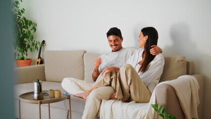 Playful family flirting couch closeup. Handsome man cuddling woman relaxing sofa