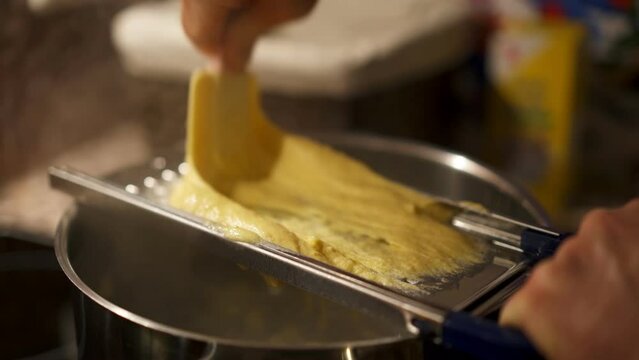 Man making traditional german Spaetzle with dough