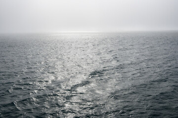 Peaceful early morning fog over the arctic ocean, water to the foggy horizon, as a nature background
