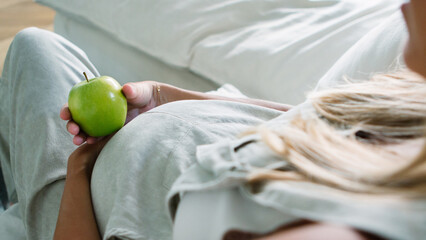 View a pregnant womanholding a bowl with fresh salad, enjoyinghealthy lifestyle during her pregnancy
