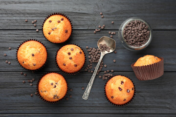 Obraz na płótnie Canvas Delicious freshly baked muffins with chocolate chips on dark gray table, flat lay