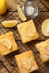 Tasty lemon bars on wooden table, top view