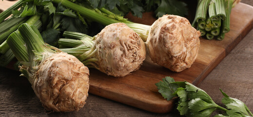 Fresh raw celery roots on wooden table, closeup. Banner design