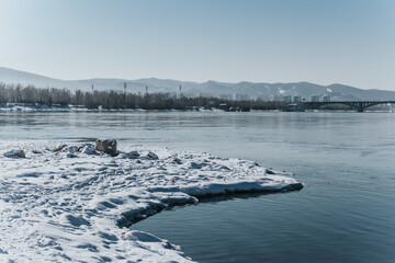 Landscape: stones covered with snow on the banks of the Yenisei