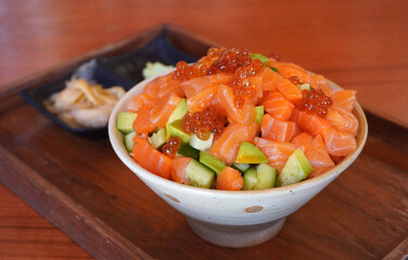 Salmon Sashimi Bowl (Donburi), selective focus. Salmon Sashimi Bowl, Steamed Japanese rice topped with fresh sashimi-grade salmon, briny salmon roe (ikura), and avocado