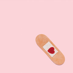 Creative composition made with medic plaster with heart shaped stain on pastel pink background....