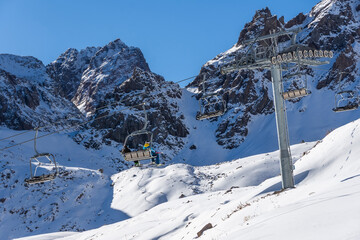 Ski resort with an open-type cable car overlooking the snow-covered valleys and the mountain cirque.