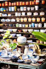 Small store with many pottery ceramic standing on shelves.