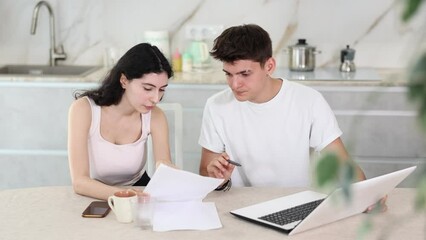 Guy manager tells girl client about specifics of design of microloan, about benefits and advantages. Seller draws up contract on laptop