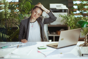 smiling modern business woman at work stretching neck