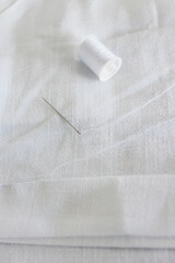 white linen shorts with thread and needle and a half-way done hem