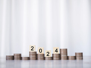 Wooden block with number 2024 on stack of coins. The concept of saving money, Financial, Investment...