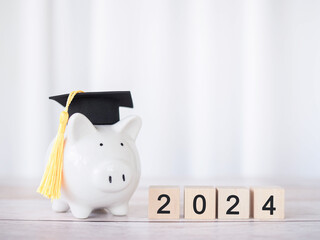 Study goals, Piggy bank with graduation hat and Wooden block with number 2024. The concept of saving money for education, student loan, scholarship, tuition fees in New Year 2024 - obrazy, fototapety, plakaty