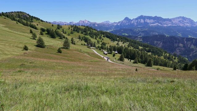 Wooden house stands amon picturesque summer nature in Dolomites. Small mountain settlement