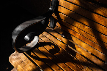armrest and its shadow on old wooden bench looks like music symbol