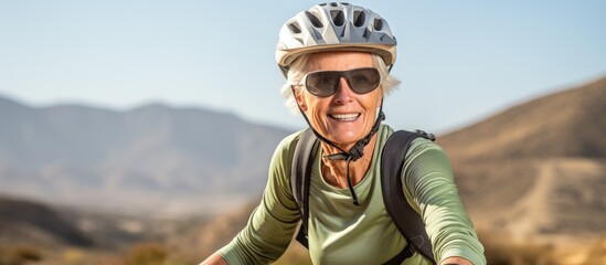 Active senior woman exploring Tabernas desert in Spain on an electric mountain bike. - obrazy, fototapety, plakaty