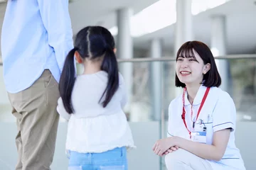 Fotobehang 病院内にて話す笑顔の看護師と患者の子供 © west_photo