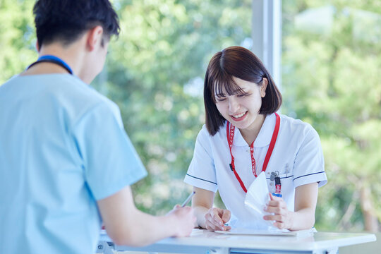 病院内にて打ち合わせを行う看護師の男女