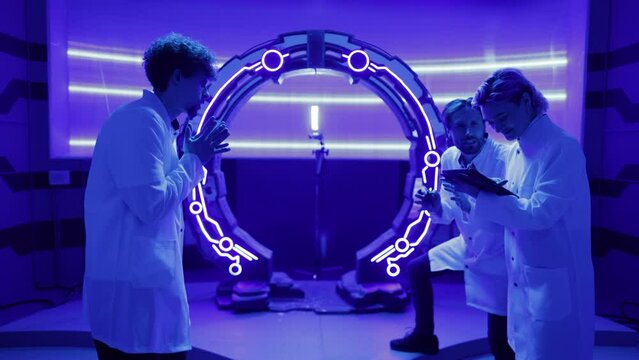 Professional crew testing new system in futuristic interior. Young male and female scientists looking joyous after successful researching tests. High quality 4k footage