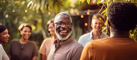 African man at a joyful multigenerational outdoor family gathering.