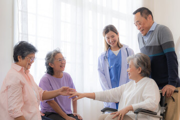Asian young nurse support couple senior older man and woman in a wheelchair. elderly mature and a group of senior friends living in the hospital. socializing of retired people. - obrazy, fototapety, plakaty