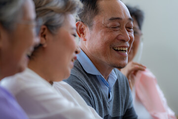 Happiness of the group females and male elderly talking with Video Call from smart tablet. Senior people are talking and enjoy together at the living room. Joyful retired friends enjoying relaxation.