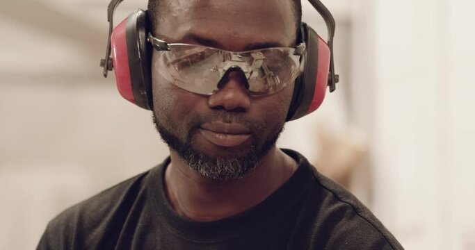 Carpenter, safety glasses and black man in workshop for manufacturing, furniture and startup business. Carpentry, creative industry and face of person working with wood, lumber or material in factory