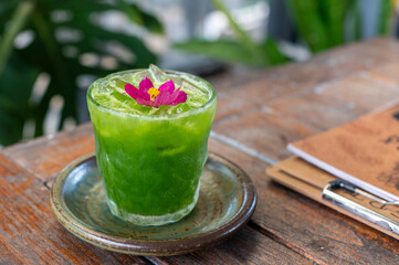 Kale juice in a glass on a wooden table