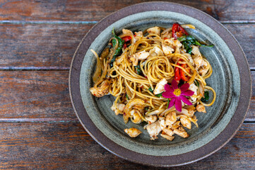 Stir-fried spaghetti with crab meat on a wooden table