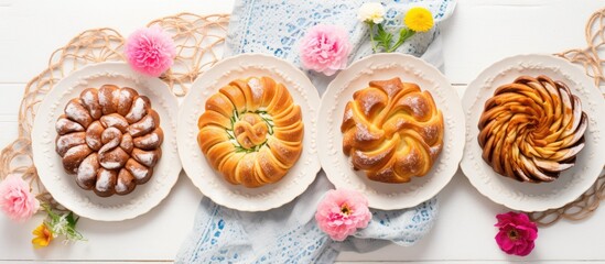 Obraz na płótnie Canvas Traditional Romanian sweet bread cozonac sliced, served on flower-decorated plates on a concrete table. Springtime Easter baking. Healthy holiday food. Top view photograph of excellent quality.